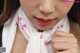 A close up of a woman wearing a white scarf with pink hearts on it.