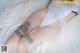 A woman laying on a bed with a tattoo on her leg.