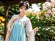 A woman in a blue and white hanbok posing for a picture.