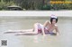 A woman in a nurse outfit laying in the water.