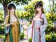 A couple of women standing next to each other in a garden.