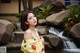 A woman in a yellow dress standing in front of a waterfall.