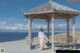 A woman in a white dress standing in front of a gazebo.