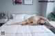 A woman laying on a bed in a white lingerie.