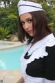 A woman in a sailor outfit posing by a pool.